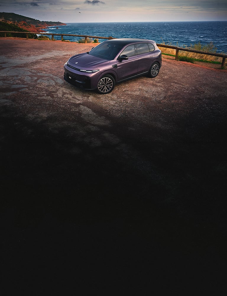 SUV Leapmotor B10 morado estacionada en un mirador costero con el océano de fondo.